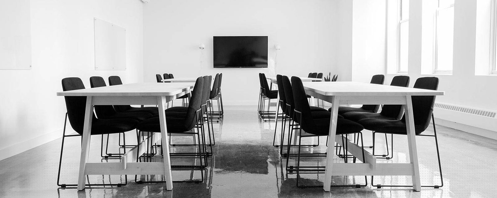 A boradroom with table and chairs, ready for a meeting